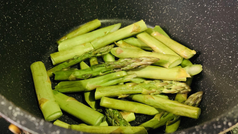 芦笋炒牛肉,锅里加食用油,倒入芦笋,翻炒;
