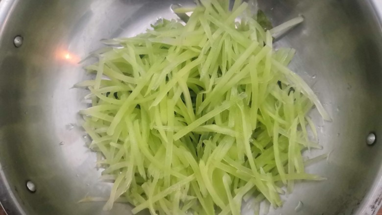 莴笋炒鸡蛋,把莴笋丝,放入盘中