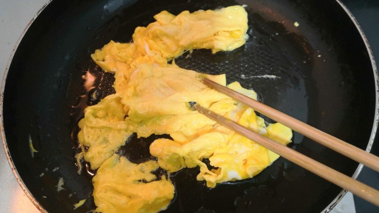 莴笋炒鸡蛋,鸡蛋液凝固后,用筷子划散,关火