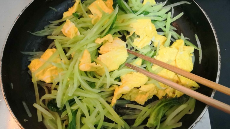 莴笋炒鸡蛋,把鸡蛋和莴笋丝,翻拌均匀
