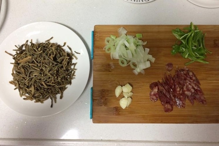 干豆角炒腊肠,将干豆角切成小段,其他食材切好备用。