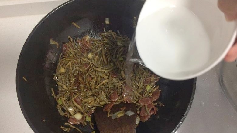干豆角炒腊肠,加入半碗水,小火炖煮约2分钟,转大火收汁。