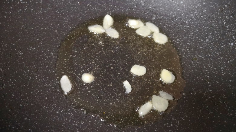 莴笋炒鸡蛋,炒锅内继续倒油烧热,下入蒜片炒香。