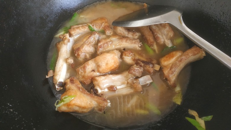 糖醋菠萝排骨,把油倒出来，放入葱，一勺料酒一勺生抽，适量盐翻炒，加入适量清水没过排骨