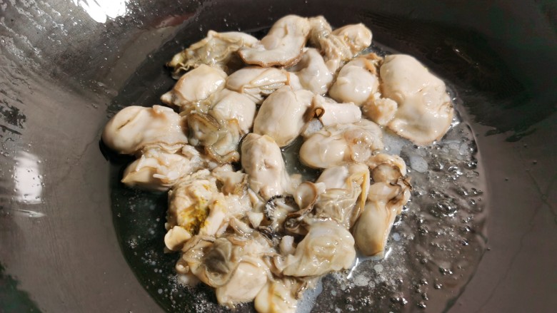 牡蛎炒蛋, 炒锅烧热放油,倒入牡蛎肉稍稍煎它一下。牡蛎煎的时间不要长了,防止变老。
