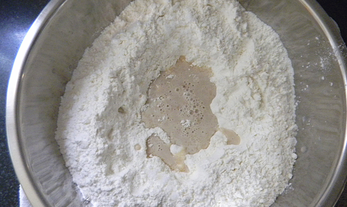 香软菊花卷,发面盆里放入面粉,糖,倒入化开的酵母粉;