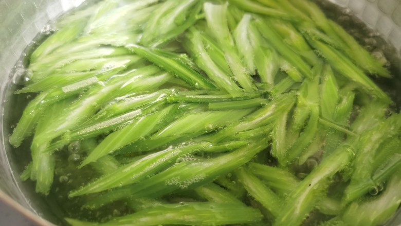 芹菜拌腐竹,锅里放水烧开,放入一小勺食盐,放入芹菜焯水。加盐焯水后的芹菜颜色会更加的翠绿。