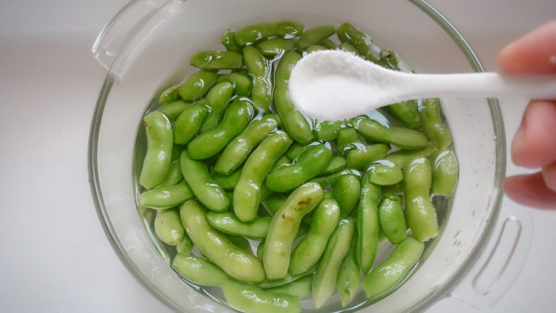 夏日炎炎之凉拌毛豆,冲洗干净后的毛豆用碗盛水泡起来,给适当盐,静置10-15分钟