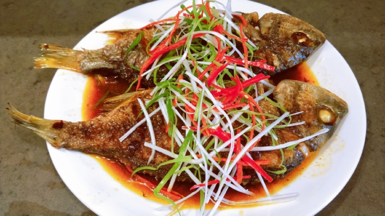 酱焖黄花鱼,撒上葱丝,红椒丝,浇上热油即可食用。