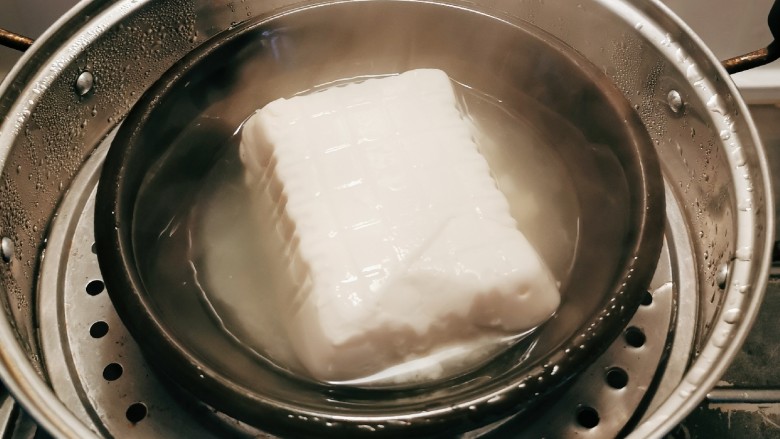 鳕鱼炖豆腐,豆腐从盒子里取出 上蒸锅蒸10分钟 取出切块 备用
