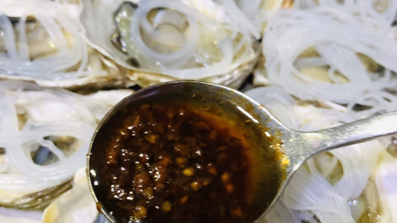 蒜蓉粉丝蒸生蚝,关火,用勺子,舀到每个生蚝上面;