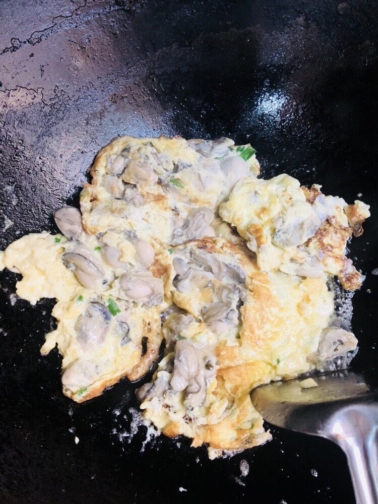 牡蛎炒蛋,一面定型后翻面继续煎。火不能大,这个就是火大了,稍微有点焦。