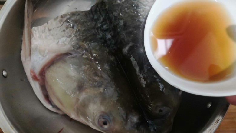 香辣烤鱼头,加入<a style='color:red;display:inline-block;' href='/shicai/ 718'>料酒</a>,用手搓揉,腌制30分钟