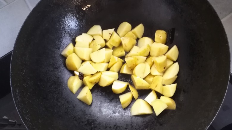 土豆鸡块焖饭,倒入土豆，翻炒（倒入一点点水）