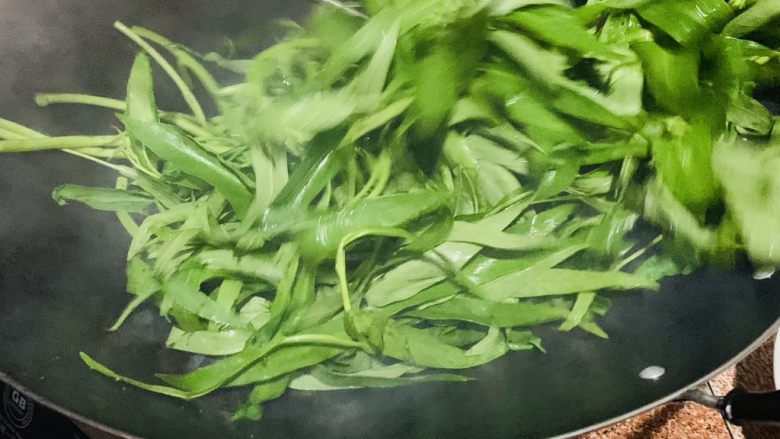 炒空心菜,加入空心菜翻炒均匀都附着上油。