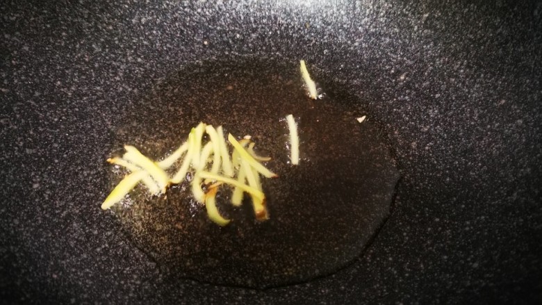 牛肉丝炒芹菜,锅中热油，先把姜丝放入锅中炝，