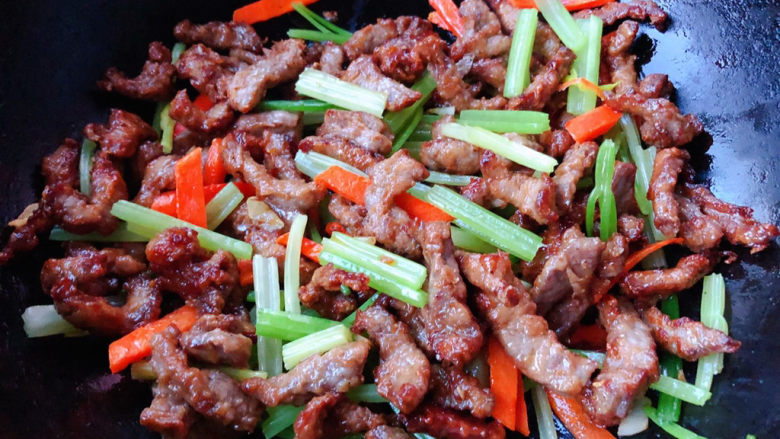 牛肉丝炒芹菜,放入芹菜和胡萝卜同时放入盐和味精炒匀