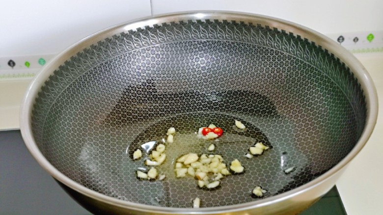 卷心菜炒粉丝,起油锅,加入蒜和辣椒炒香。