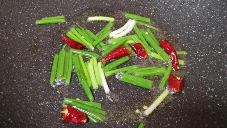 芹菜炒木耳,炒锅内继续倒油烧热,下入葱段和干红辣椒爆香。