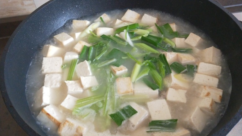 牡蛎豆腐汤,倒入水淀粉勾芡,倒入芹菜,蒜苗。