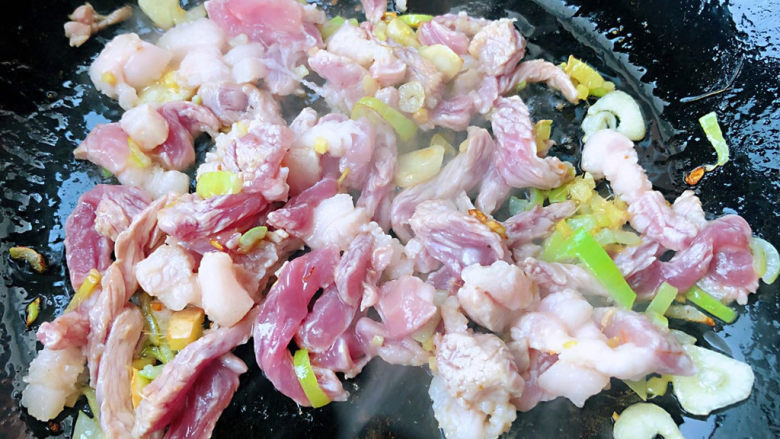 卷心菜炒粉丝,锅中倒入底油加热放入葱姜蒜爆香放入鲜猪肉炒至变色