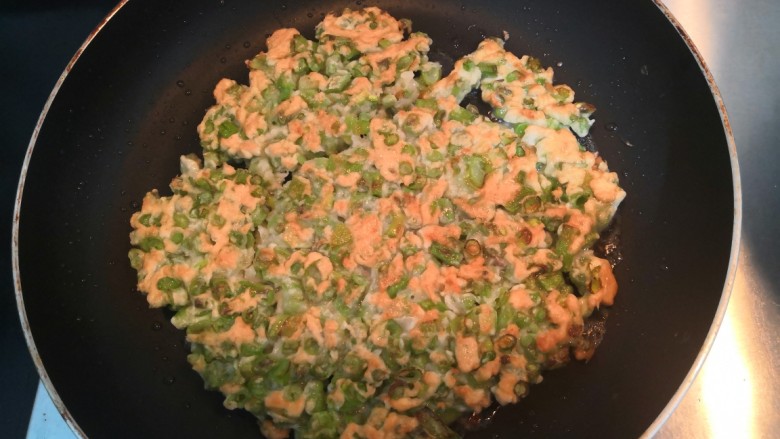 长豆角蛋饼,一面煎金黄后,翻面,再煎至金黄,关火