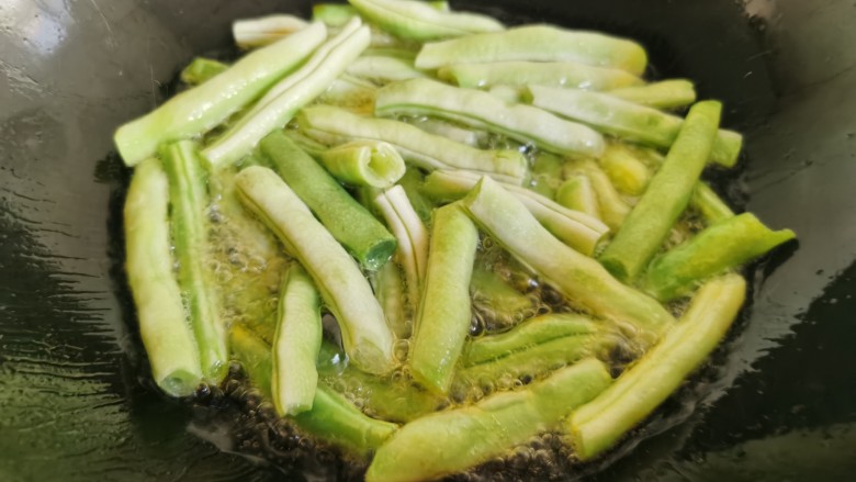 干煸芸豆,锅里放入多一点的油,放入芸豆段炸熟。