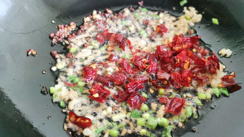 干煸芸豆,锅里留一些底油,放入干辣椒,花椒,葱、姜、蒜爆香。