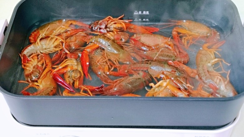 蒜香小龙虾,锅中加入水大火烧开后下入小龙虾焯水,煮1分钟捞出。(可以根据个人喜欢选择是否需要焯水,个人觉得烫一下再烧更卫生)