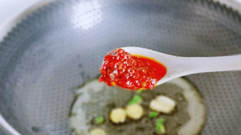 香辣鱿鱼须,起油锅,加入葱姜蒜炒香,红辣椒段,再加入1勺辣肉酱,可以根据个人喜好增加。