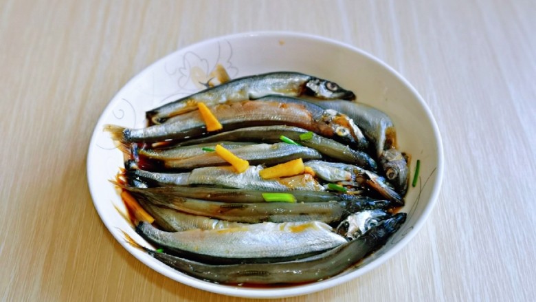 酥炸多春鱼,按个人口味加入盐,再淋上1小勺食用油,拌均匀,腌制30分钟。