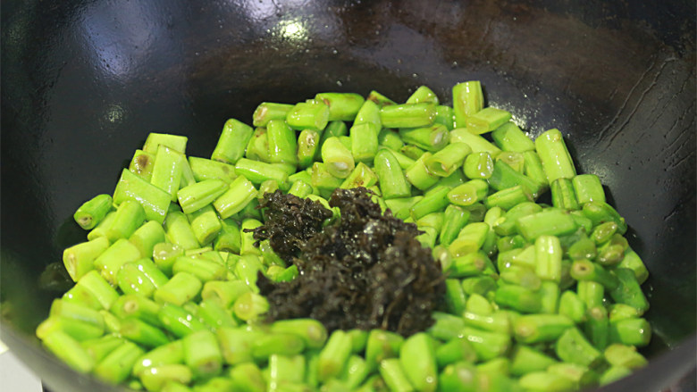 橄榄菜炒四季豆,倒入橄榄菜;