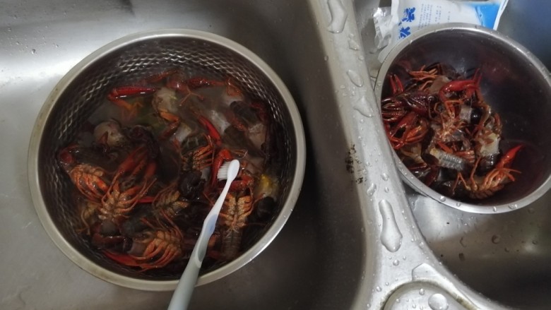 蒜香小龙虾,将小龙虾用牙刷把身体上泥沙刷洗干净,剪掉头尾。