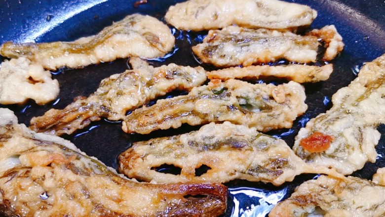 炸香椿鱼,等一面炸至金黄,翻面再把另一面炸至金黄酥脆即可
