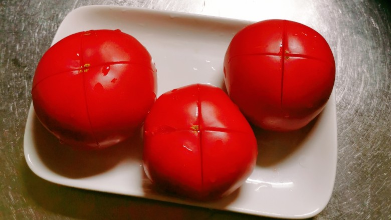 番茄黑鱼片,<a style='color:red;display:inline-block;' href='/shicai/ 59'>番茄</a>顶端划十字刀 放入开水汆烫