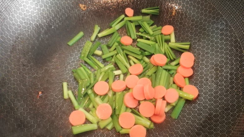 酱油炒面,锅中再放少许油,接着放入韭菜梗和火腿肠,翻炒均匀