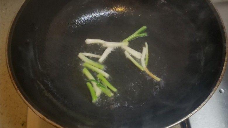 葱油蚕豆,起锅热油,把葱白先放进锅中小火煎