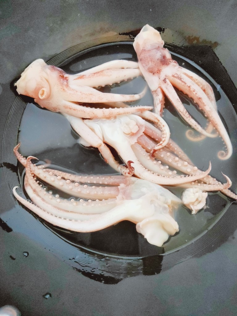 鱿鱼炒芹菜,水开后放入鱿鱼煮约1分钟,鱿鱼缩水即可捞起