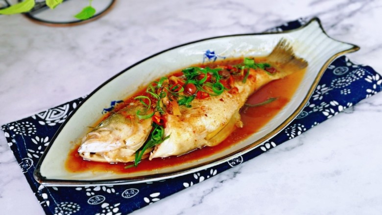 葱油鲈鱼,取出鱼盘,淋上热油,撒上葱花。(锅中加入食用油烧热淋在鱼身上)