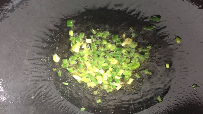 葱油蚕豆,锅里放入适量的油,爆香一部分葱花