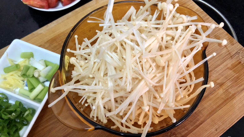黄瓜金针番茄鱼滑汤,金针菇切去根部,撕散清洗备用