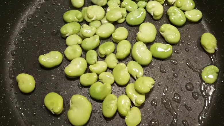 油焖蚕豆,油热后放入蚕豆 炒熟捞出
