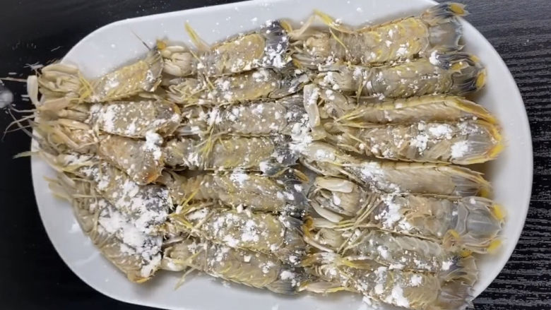 椒盐皮皮虾,腌制好的皮皮虾,要控干水份,可以用吸油纸轻轻按压,吸一下水,这样一会炸的时候不会油花四溅。然后均匀洒上一层干粉
