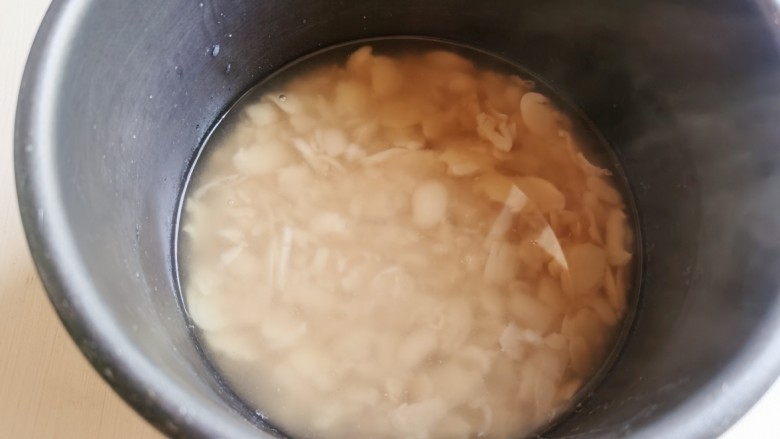 芸豆糕,去皮的白芸豆加水,放锅里煮至熟烂。我是放电饭煲里煮的,用压力锅煮也可以。如果煮好后的水比较多,可以适当的倒出一些,不然打出的豆糊很稀,炒豆沙时会比较费时间。