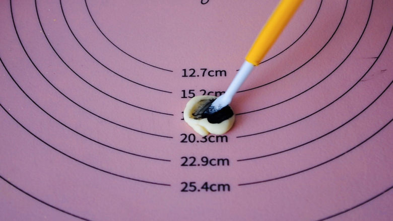 南瓜馒头,取2克白色面团加一点点竹炭粉，揉成黑色面团。