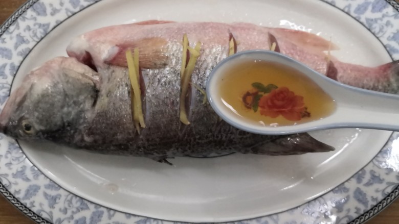 葱油鲈鱼,把<a style='color:red;display:inline-block;' href='/shicai/ 718'>料酒</a>洒入 ,腌制半小时