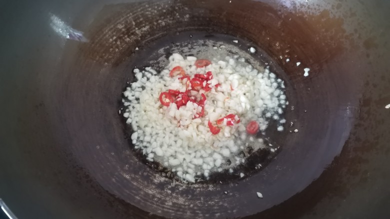 清蒸蛏子,锅里加入适量的油,油热倒入蒜末小米辣炒出香味