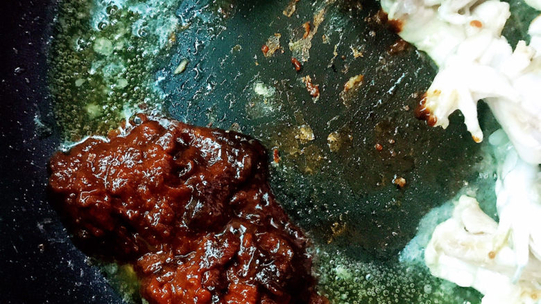 酱香牛蛙,将牛蛙推到一边,放入豆瓣酱炒香
