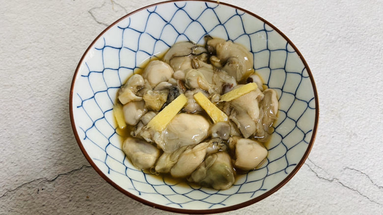 生蚝煎蛋,将生蚝放入碗中，加入适量的<a style='color:red;display:inline-block;' href='/shicai/ 864'>蒸鱼豉油</a>、<a style='color:red;display:inline-block;' href='/shicai/ 718'>料酒</a>、<a style='color:red;display:inline-block;' href='/shicai/ 756'>鸡精</a>、<a style='color:red;display:inline-block;' href='/shicai/ 134296'>白胡椒粉</a>、姜丝腌制片刻