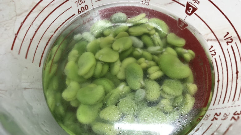 葱油蚕豆,将煮熟的豆瓣泡入凉水降温,这样更可以保持翠绿